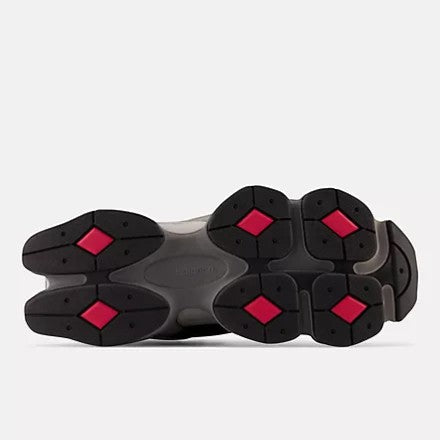 Aurore New Balance 9060 sneakers in black, castlerock, and rain cloud with red diamond accents on the sole.